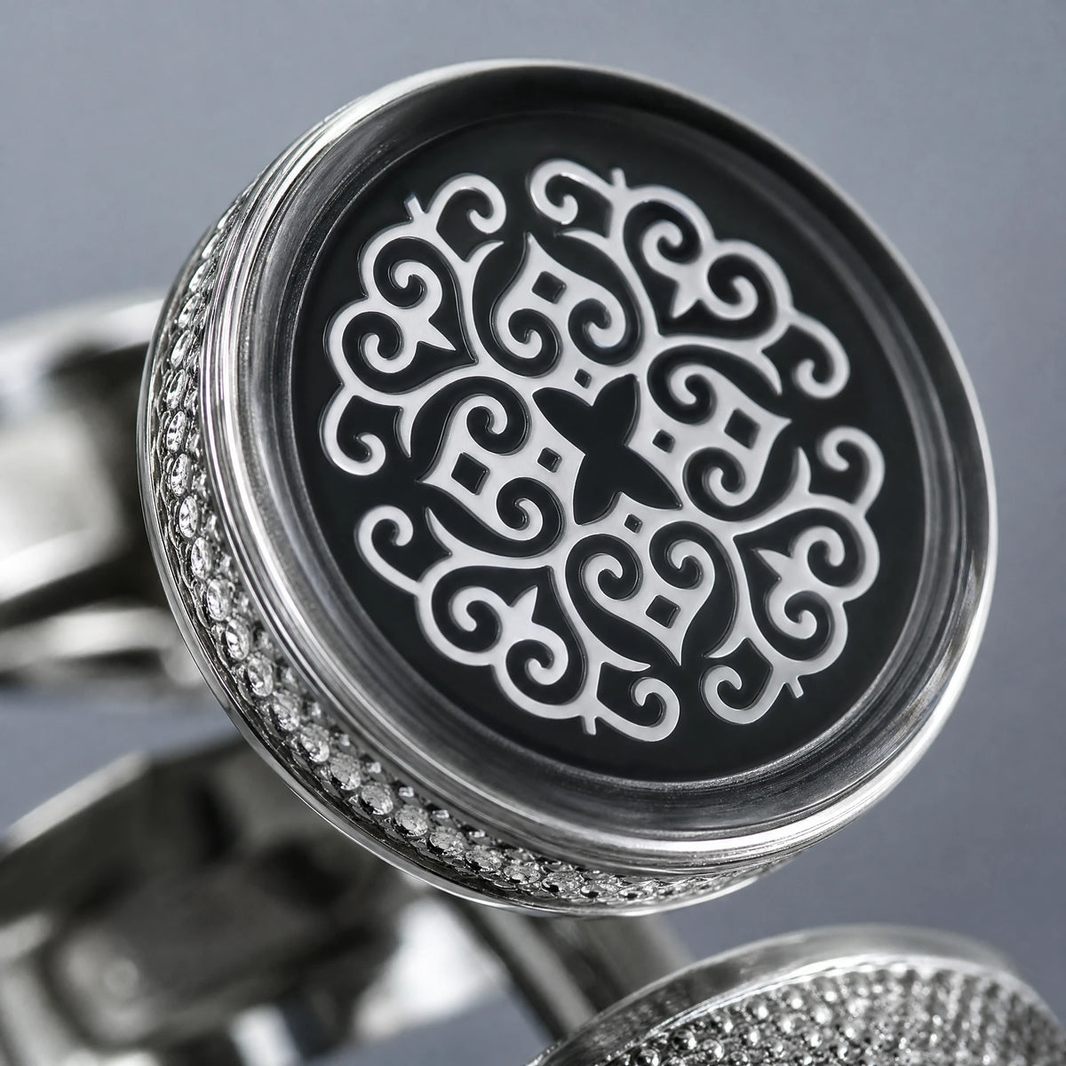 Boutons de manchette argentés motif arabesque baroque - close-up détail matière