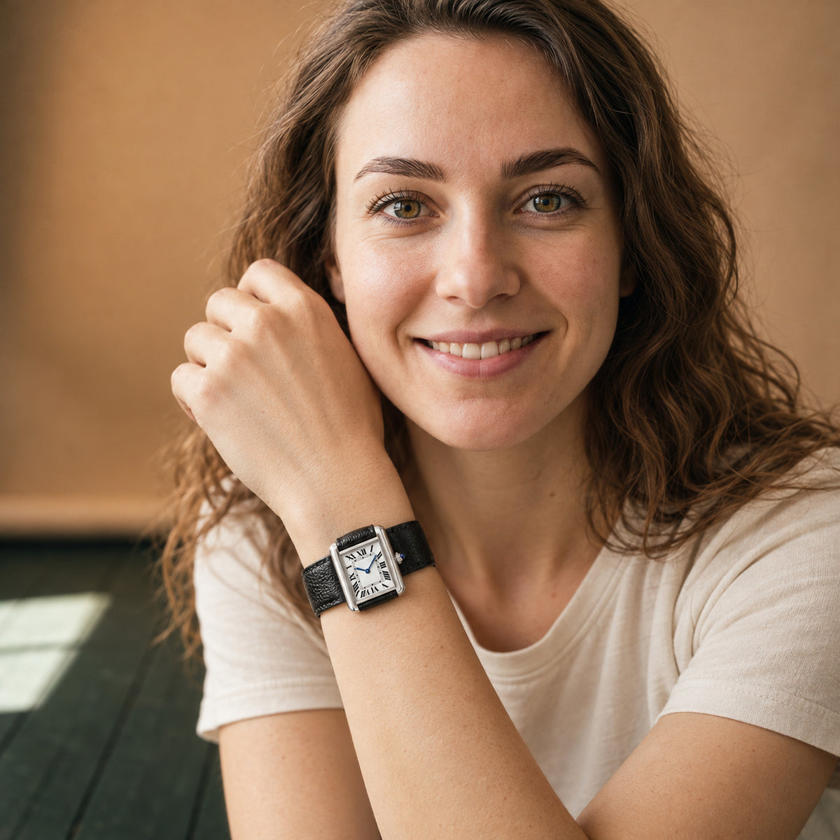 Montre rectangulaire femme à cadran blanc et chiffres romains portée au poignet, bracelet noir grainé, vue en studio Imagen
