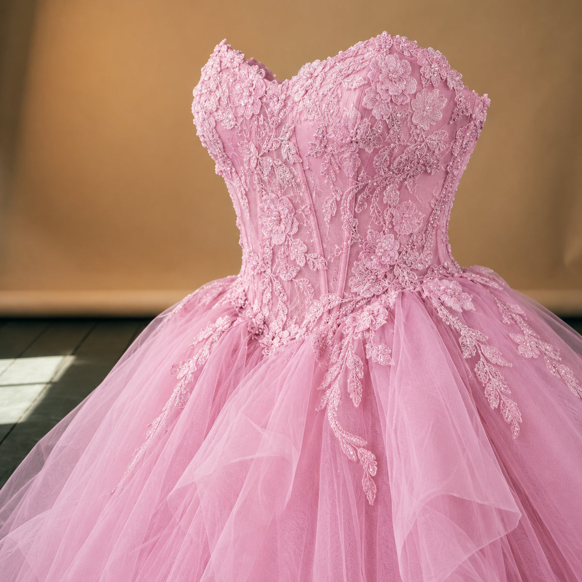 Gros plan sur les appliqués fleuris du bustier et la jupe vaporeuse de la robe charleston mariage ado rose Imagen