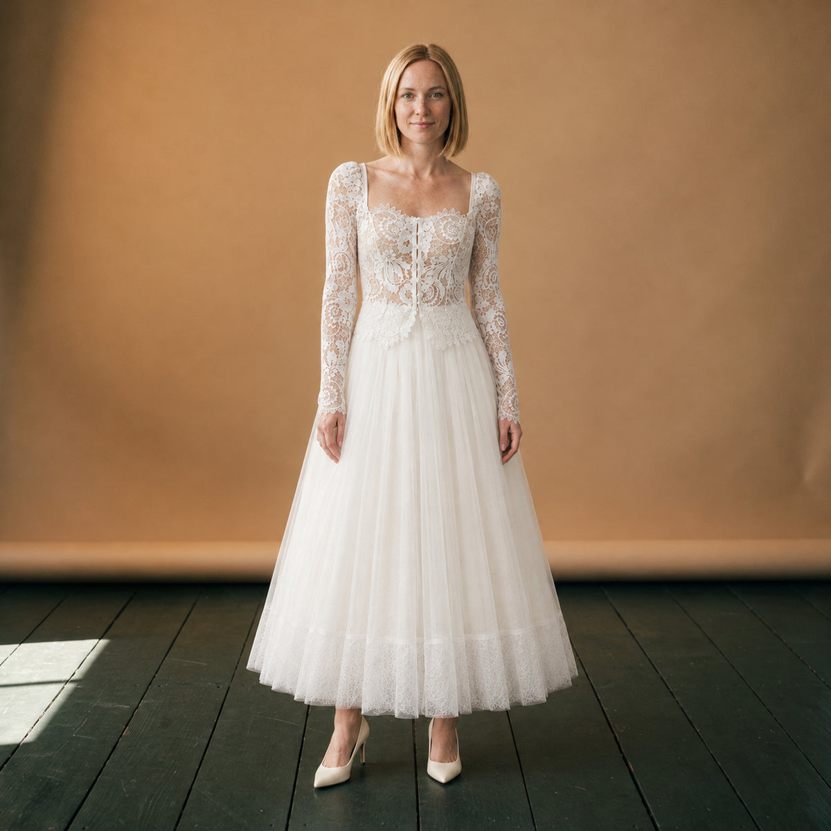 Robe de mariée vintage deux pièces en dentelle portée en studio, manches longues et jupe en tulle Imagen