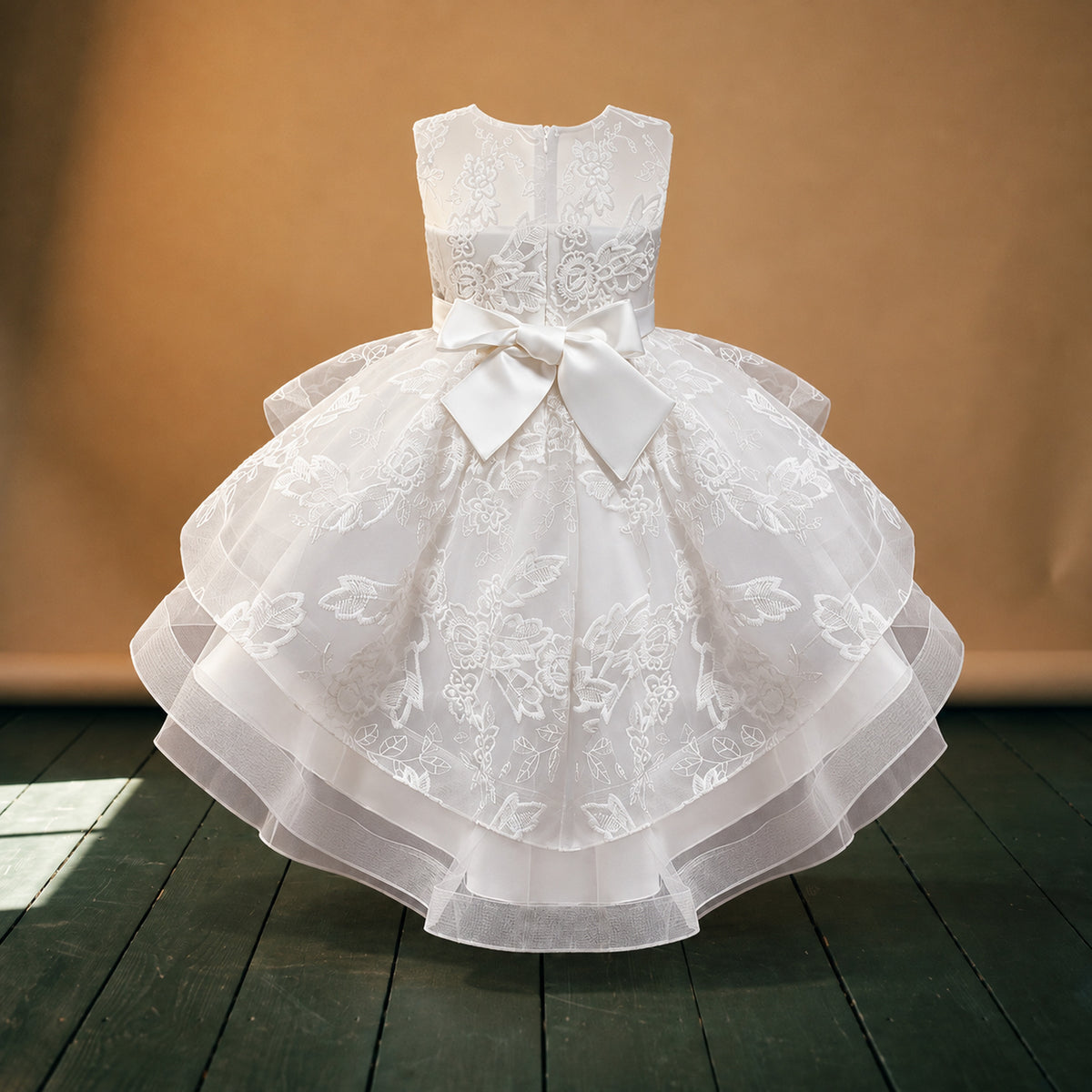 Robe de mariage petite fille style charleston blanche portée en studio par une fillette, jupe à volants, vue de face Imagen
