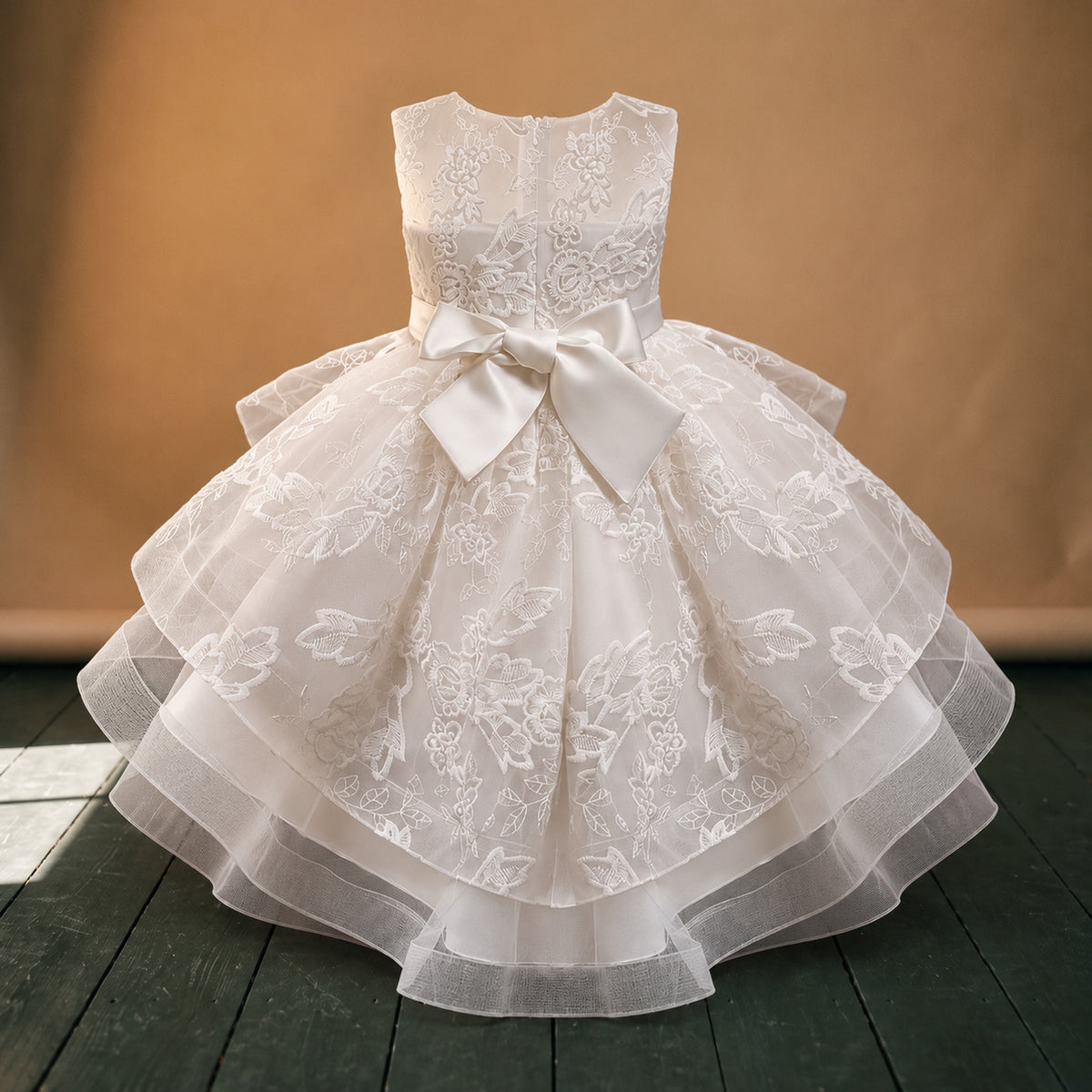 Gros plan sur les broderies fleuries et les volants de la robe de mariage petite fille style charleston Imagen