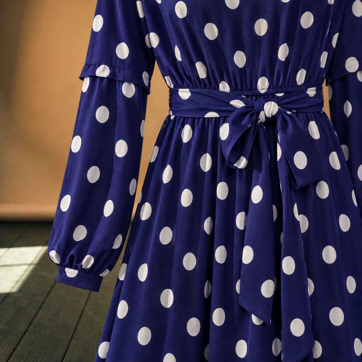 Gros plan sur les pois blancs, le polyester léger et la ceinture nouée de la robe maxi années 80 à pois bleus Imagen