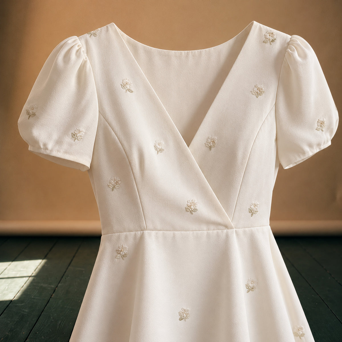 Gros plan sur les petites fleurs brodées et le tissu lisse de la robe style charleston pour mariage Imagen